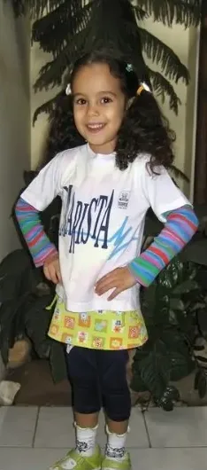 Mariana criança em pé, de camiseta e meias listradas