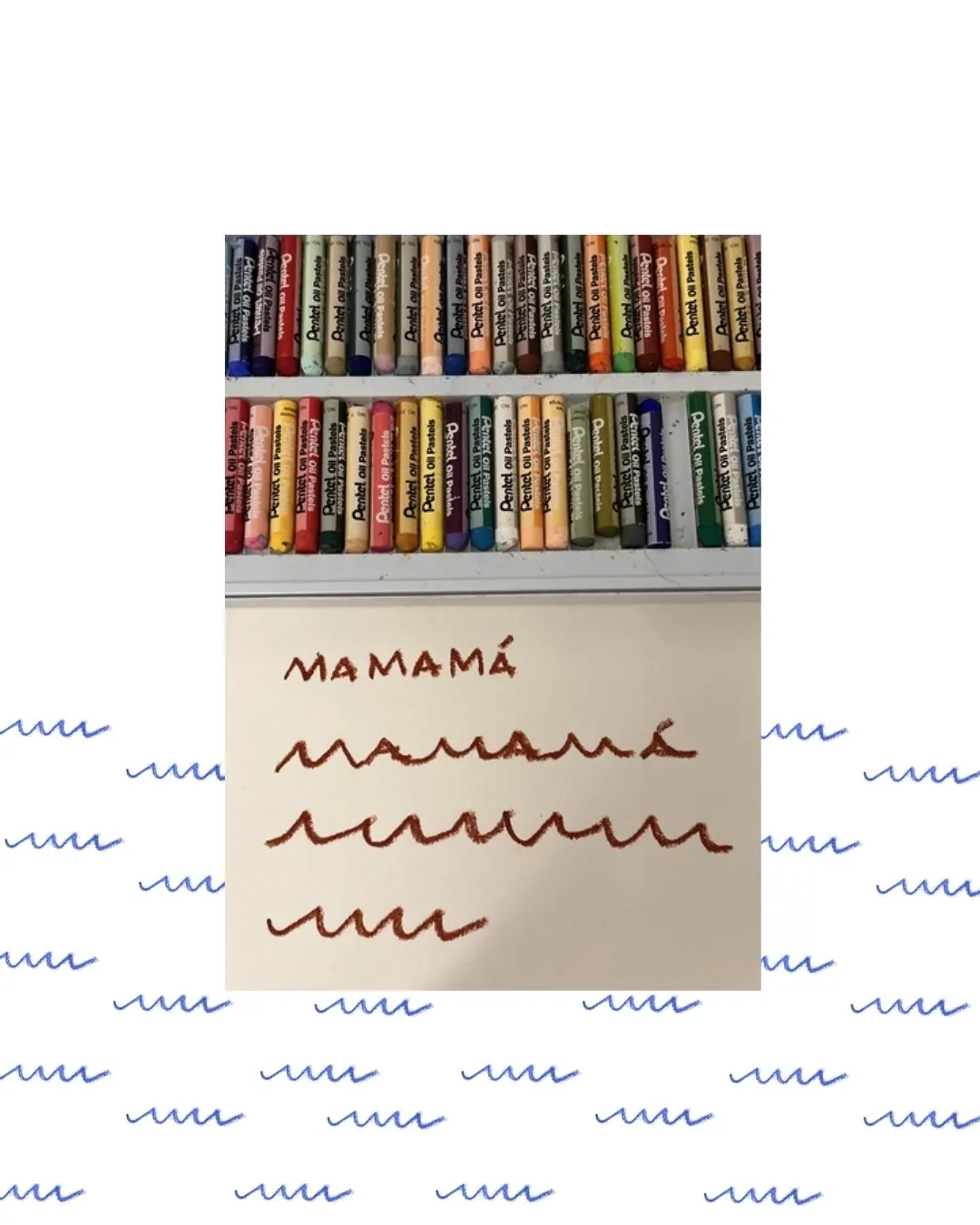 Caixa de pastéis oleosos e uma folha com MAMAMÁ escrito à mão em quatro linhas, virando ondinhas até o risquinho